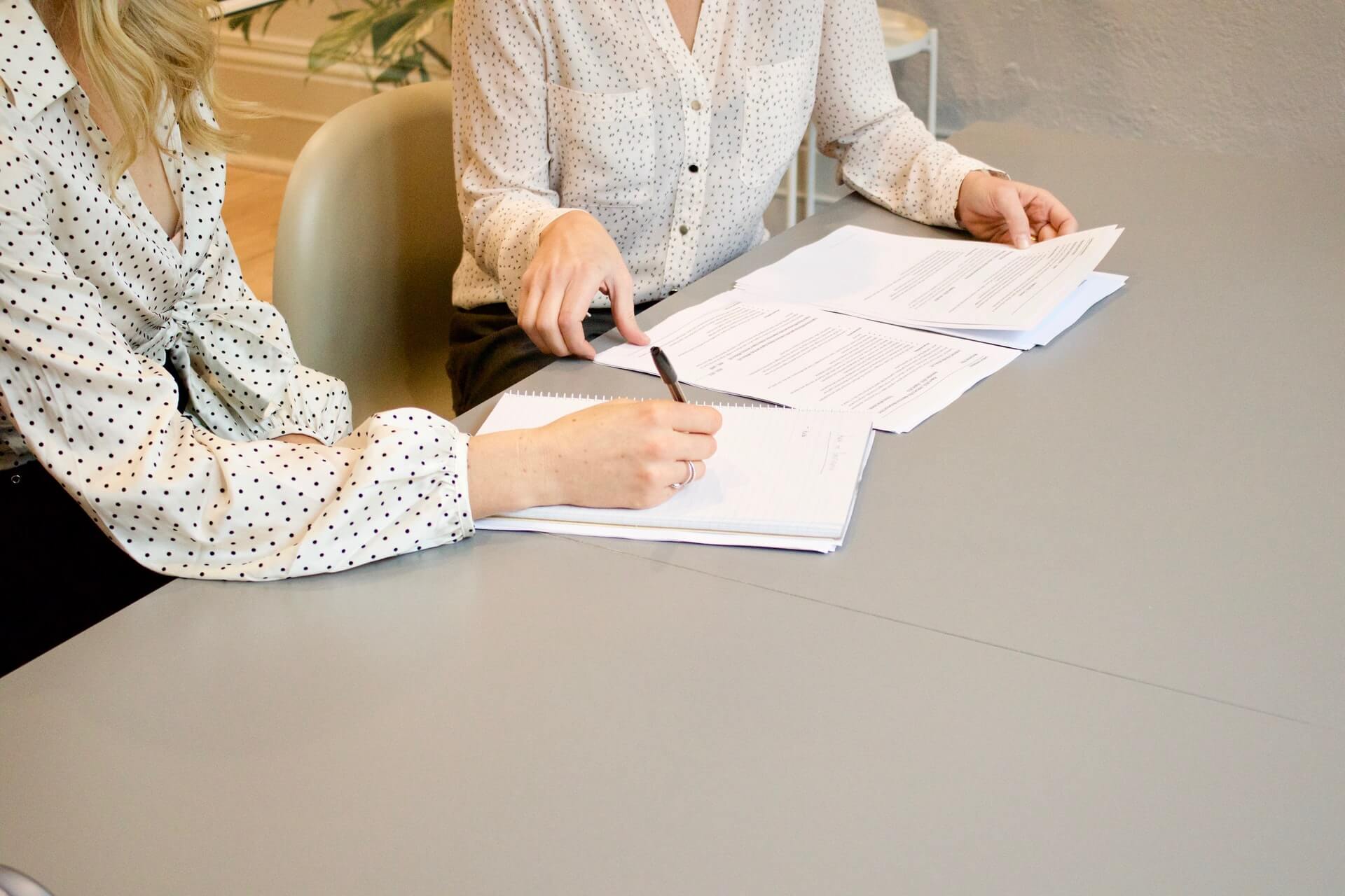 Two colleagues reviewing work documents together in the office