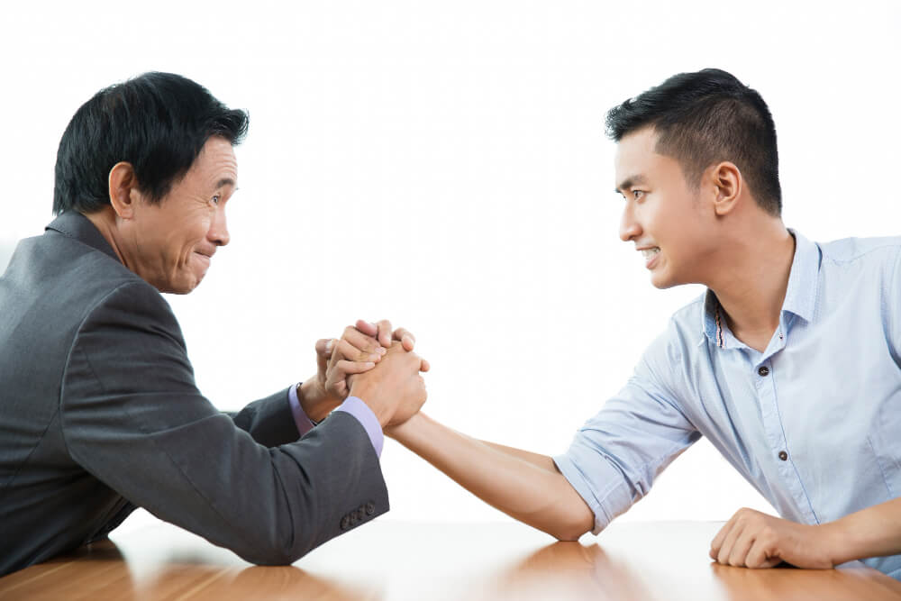 Two business men in an arm wrestling competition