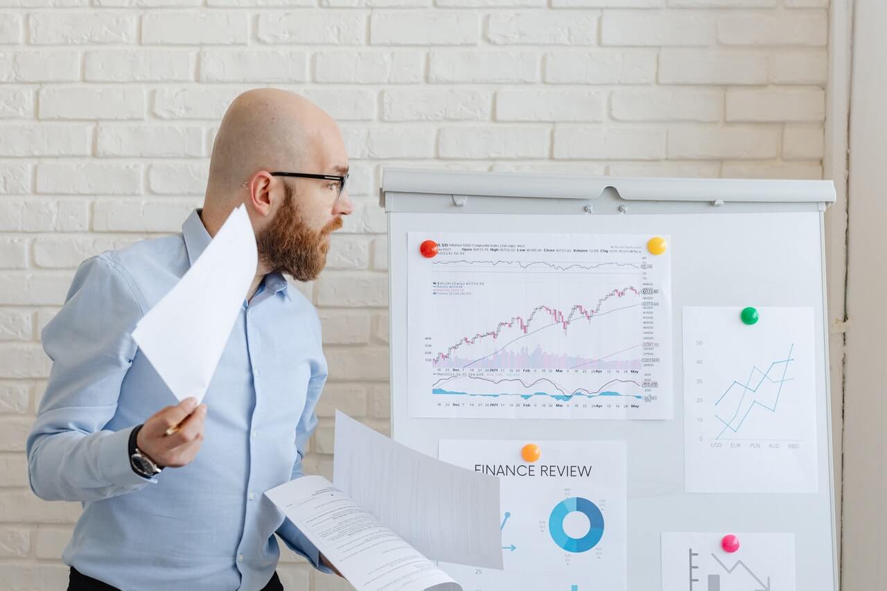 Businessman studying graphs and charts on a white board