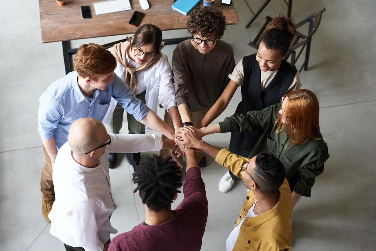 Happy business team members making a hand-stack