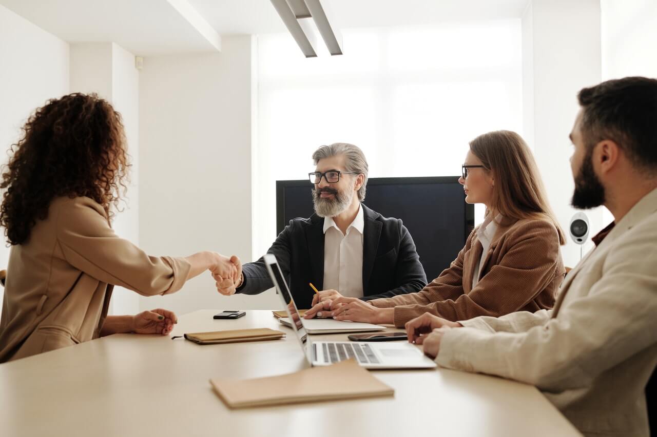 Manager shaking hands with a new employee in an office space