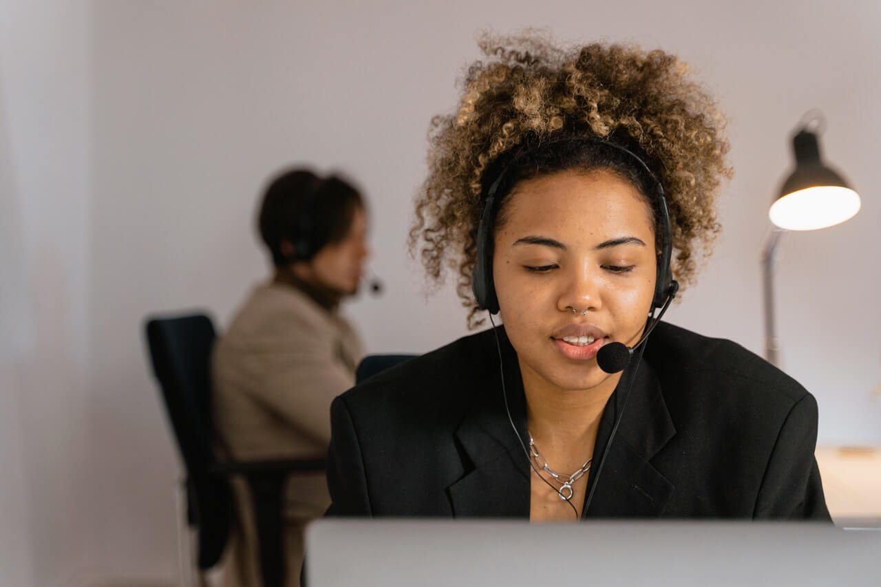 Woman in black blazer talking to a customer over the phone