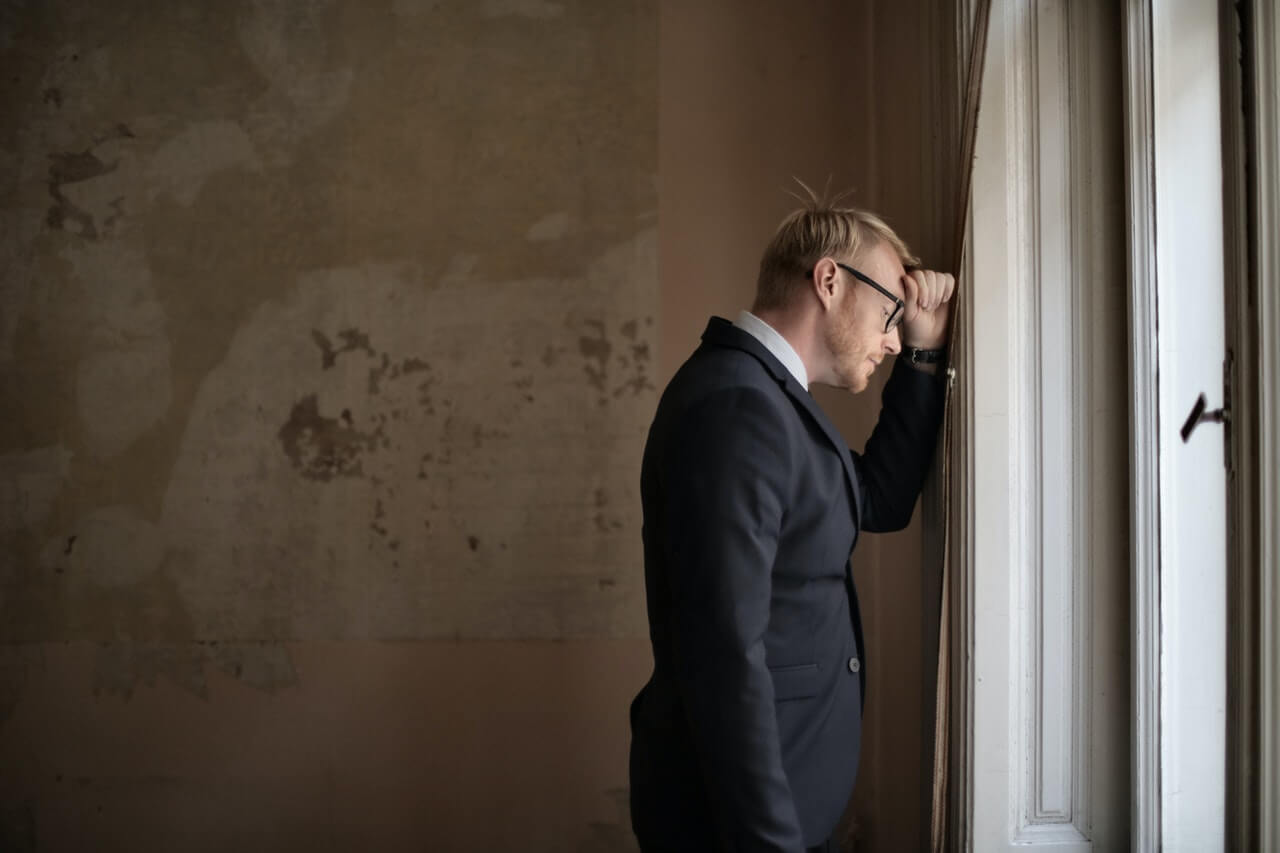 A depressed man and leaning on the wall