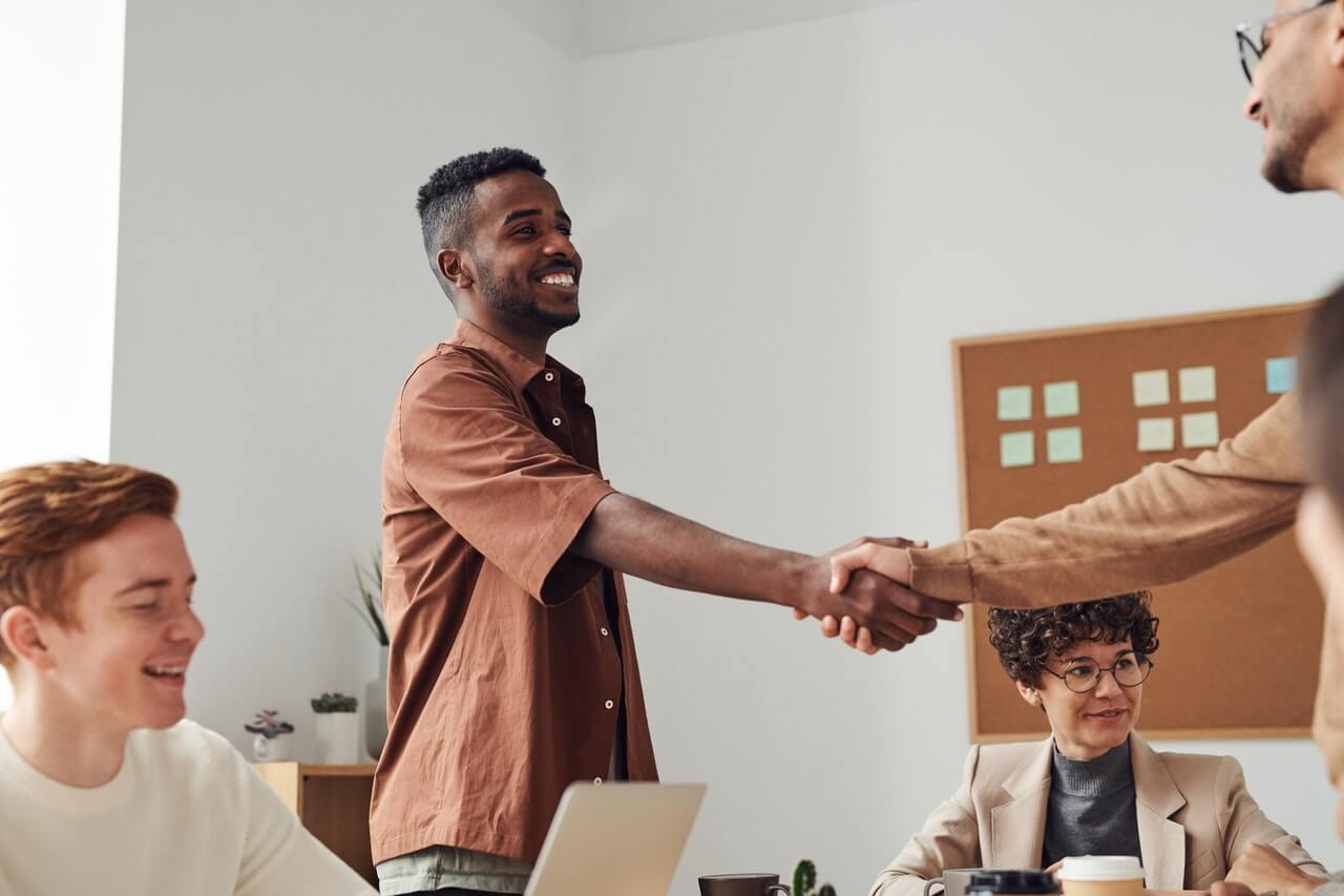 Shaking hands while smiling with a potential donor