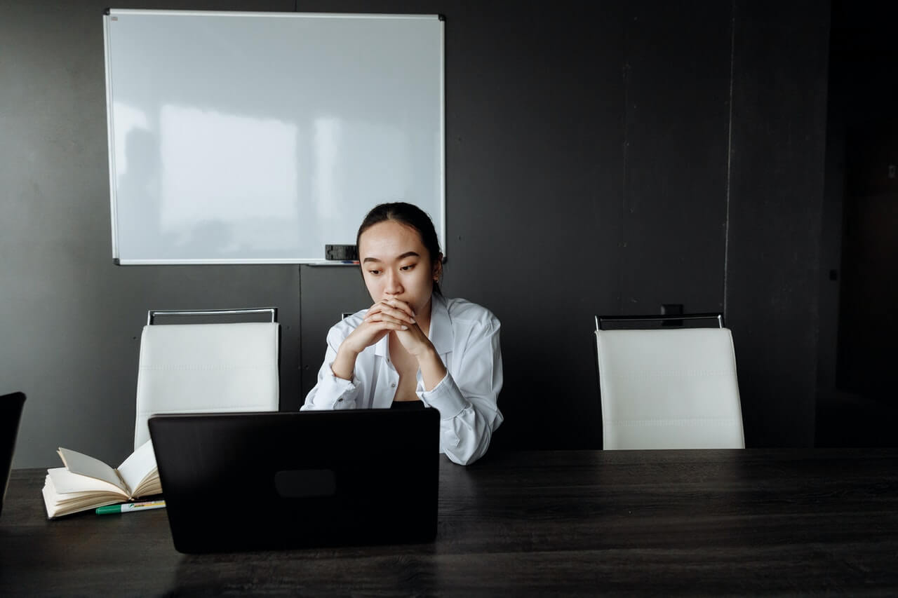 Businesswoman thinking while staring at her laptop