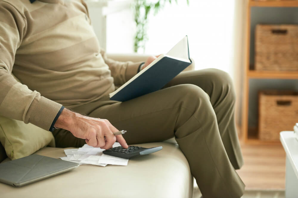 An elderly man calculating his retirement income