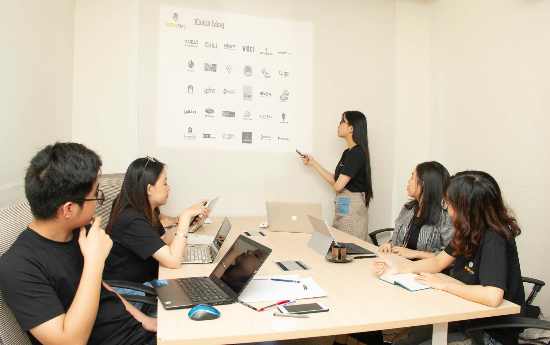 Woman presenting with a projector in a workspace