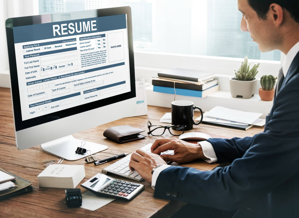 Businessman studying a resume on his laptop