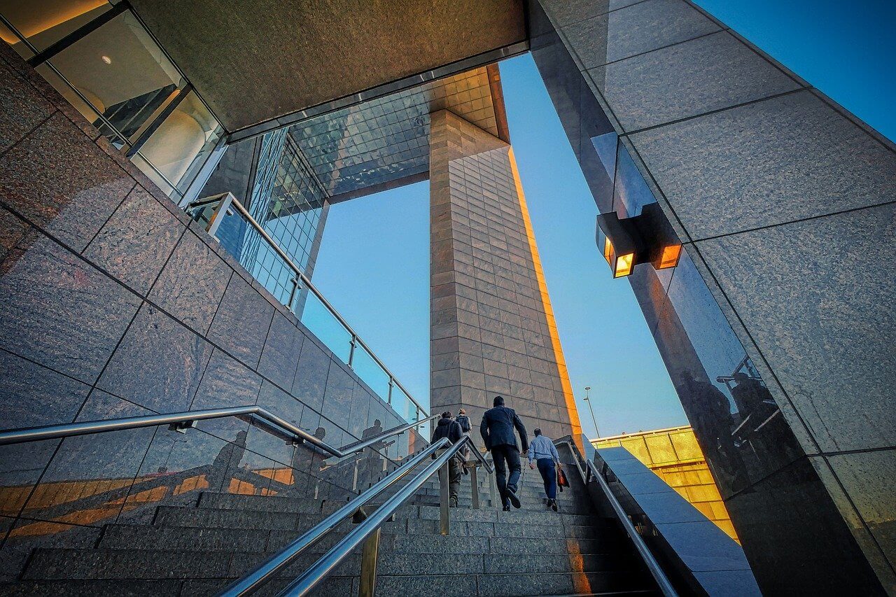 Business professionals going into a corporate building through the stairs