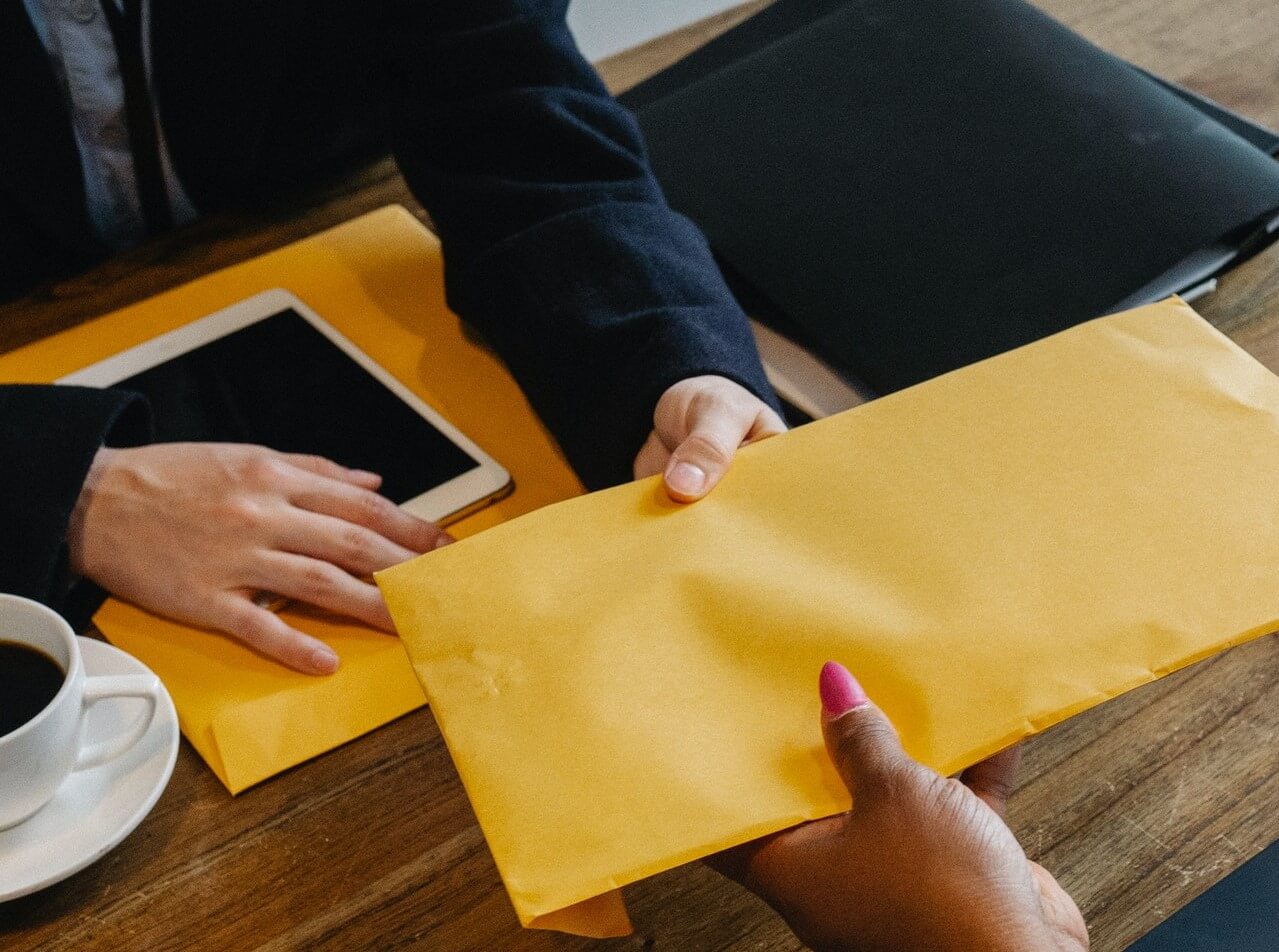 A donor handing an envelop over to an organization