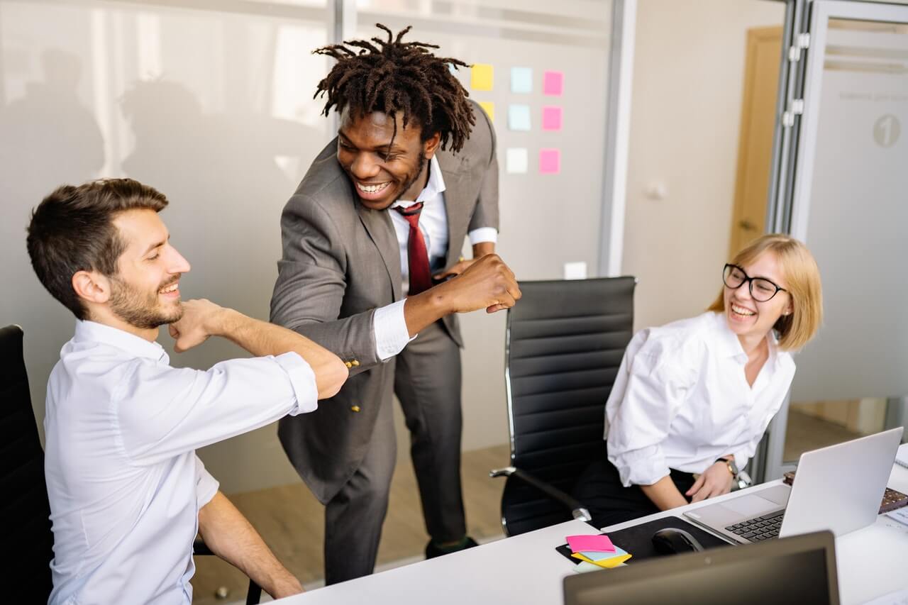 3 Millennials professionals laughing together in an office