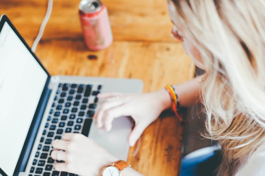 A young woman working on a proposal on her laptop