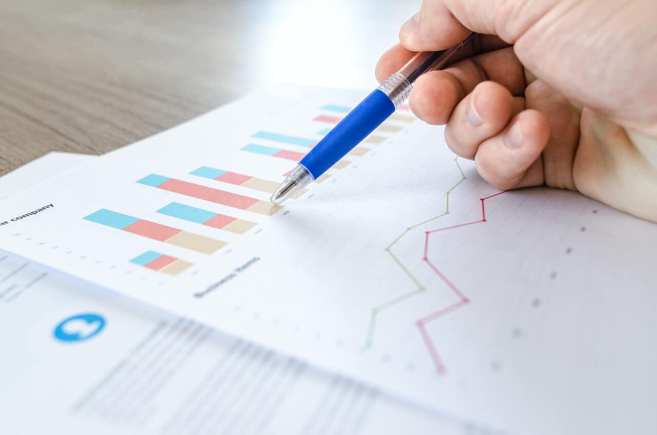 Person studying bars and graphs on a sheet of paper