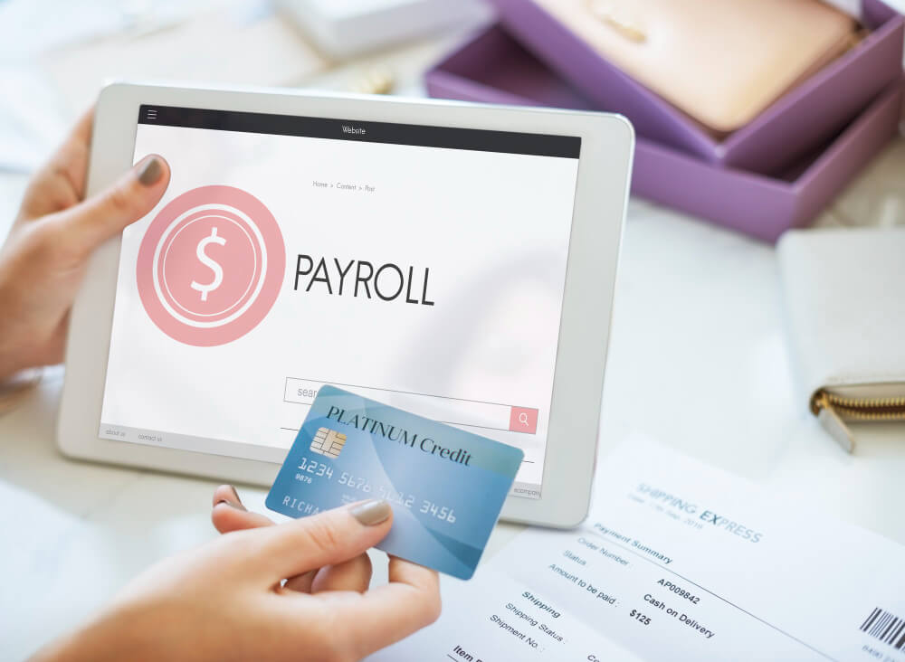 Person holding a payroll card and a tab