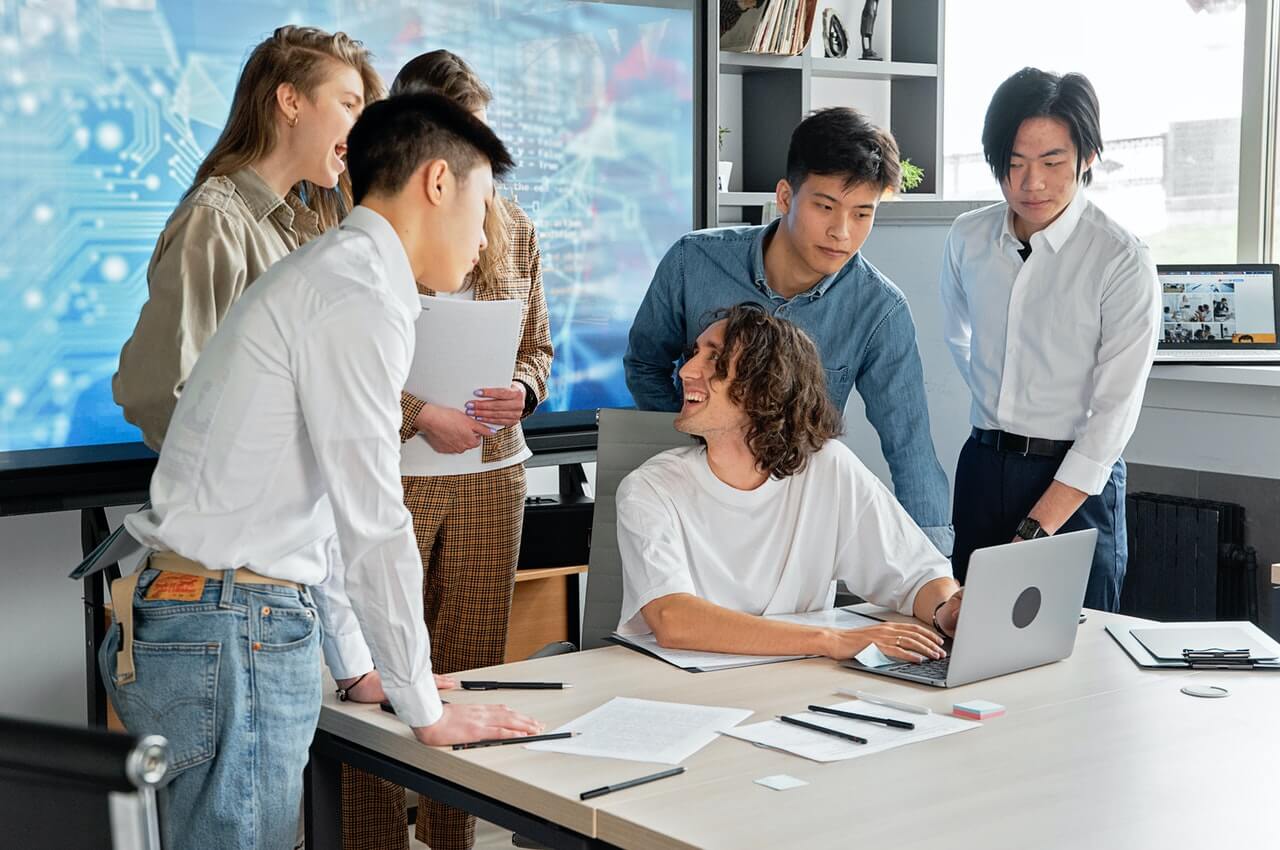 A-group-of-colleagues-working-with-a-laptop-in-an-office