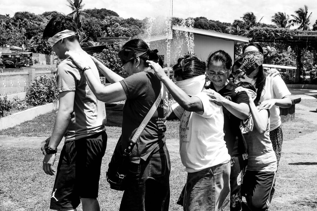 A-group-of-people-blindfolded-and-holding-each other