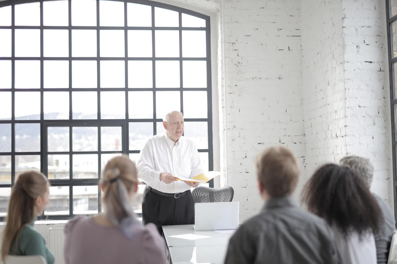 An-elderly-man-talking-to-a-group-of-people