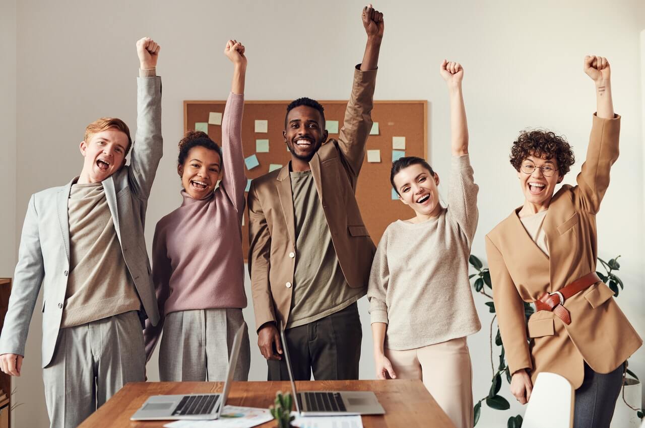 An-office-team-mates-raising-their-hands-in-excitement.