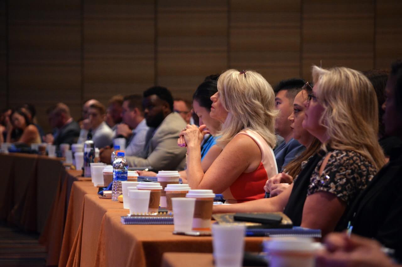 Group-of-people-seated-on-the-front-row-of-a-training-session