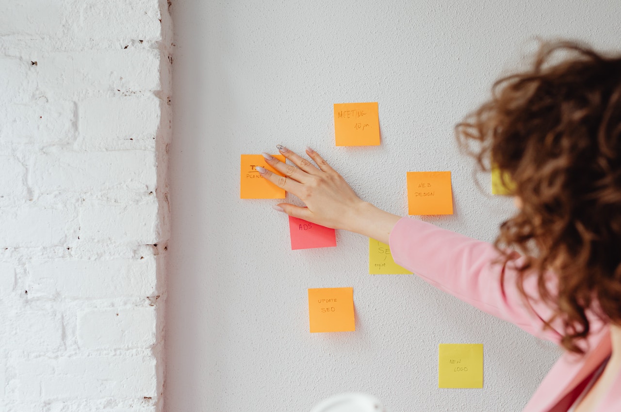 Person-sicking-papers-on-a-white-board.