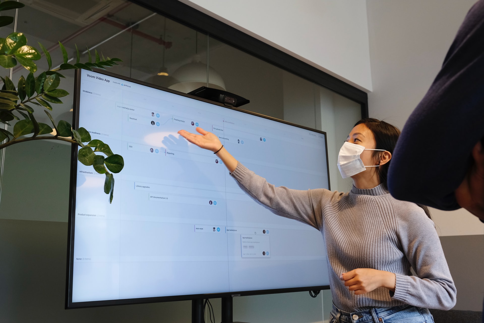 a focus lady speaking and pointing to the screen