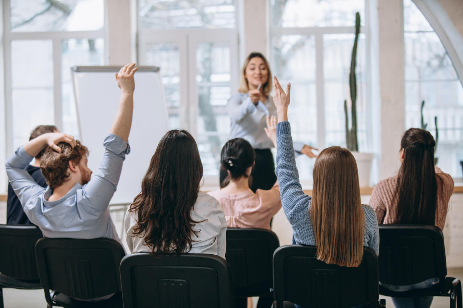 Female speaker giving a presentation to workers in a conference hall