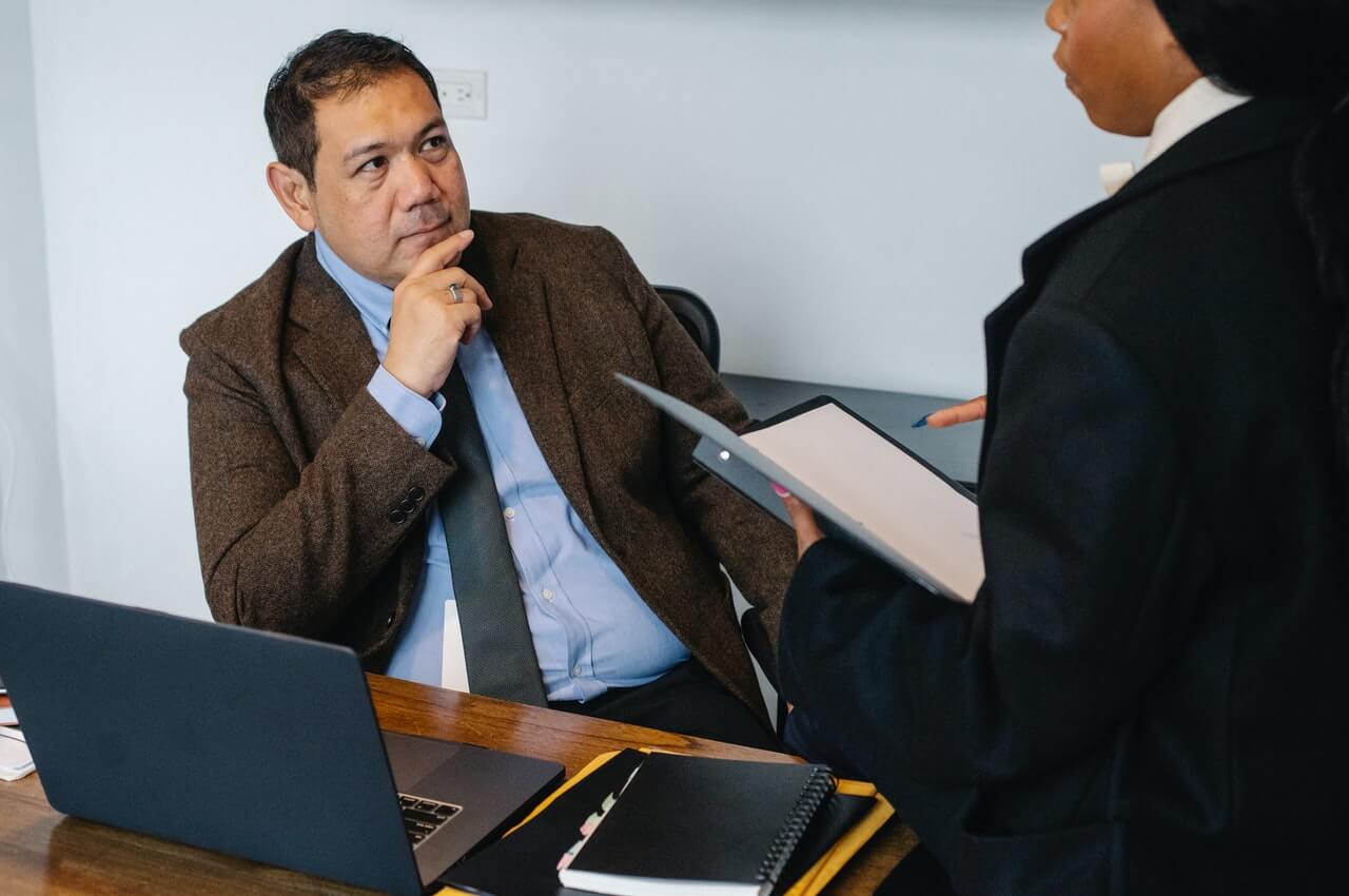 A-business-man-reviewing-a-document-with-his-secretary.