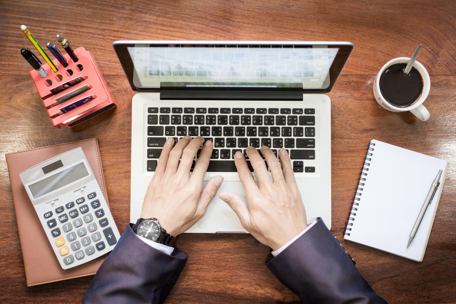 A-business-man-with-his-two-hands-working-on-his-laptop