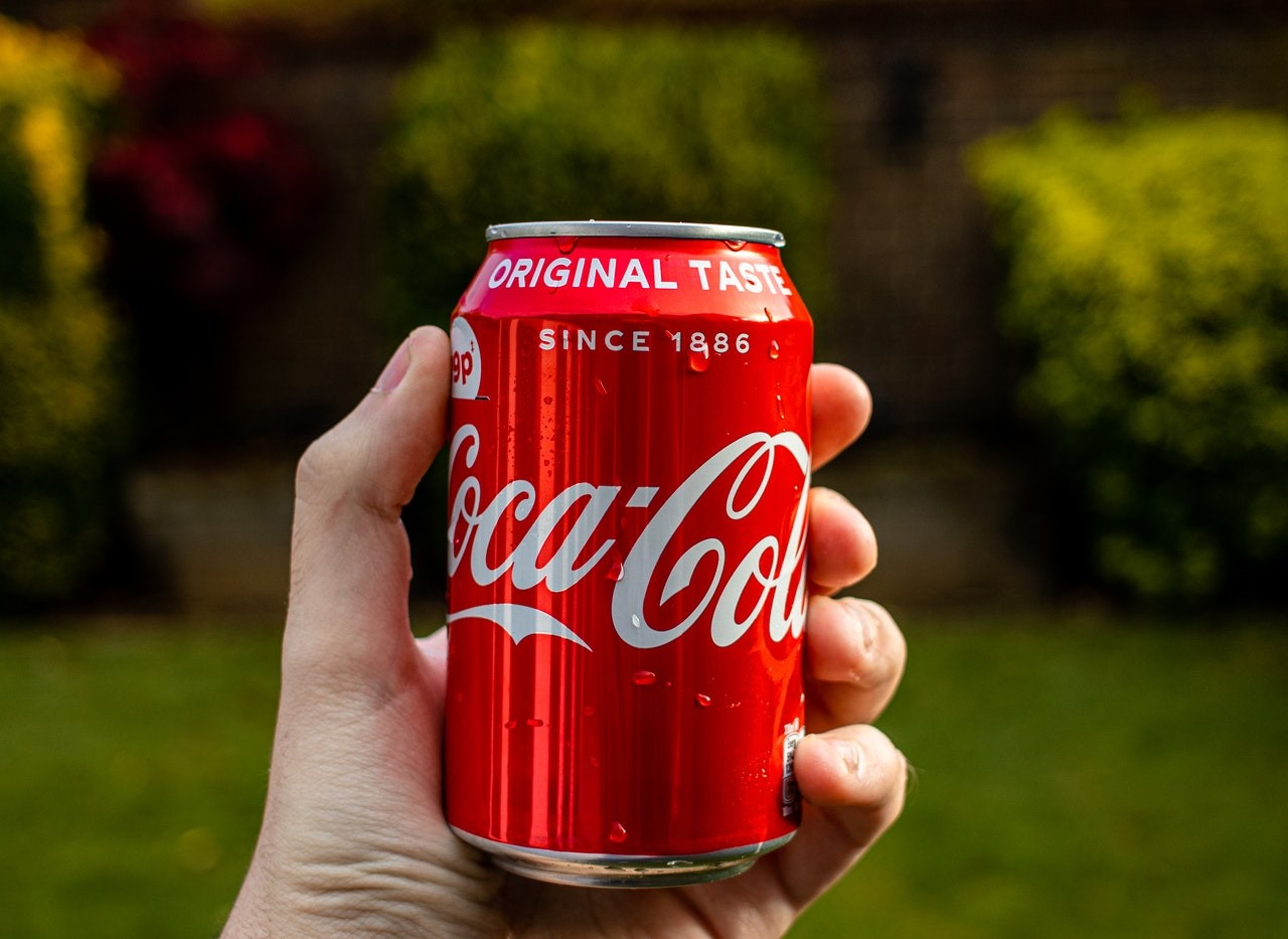 A hand holding a can drink