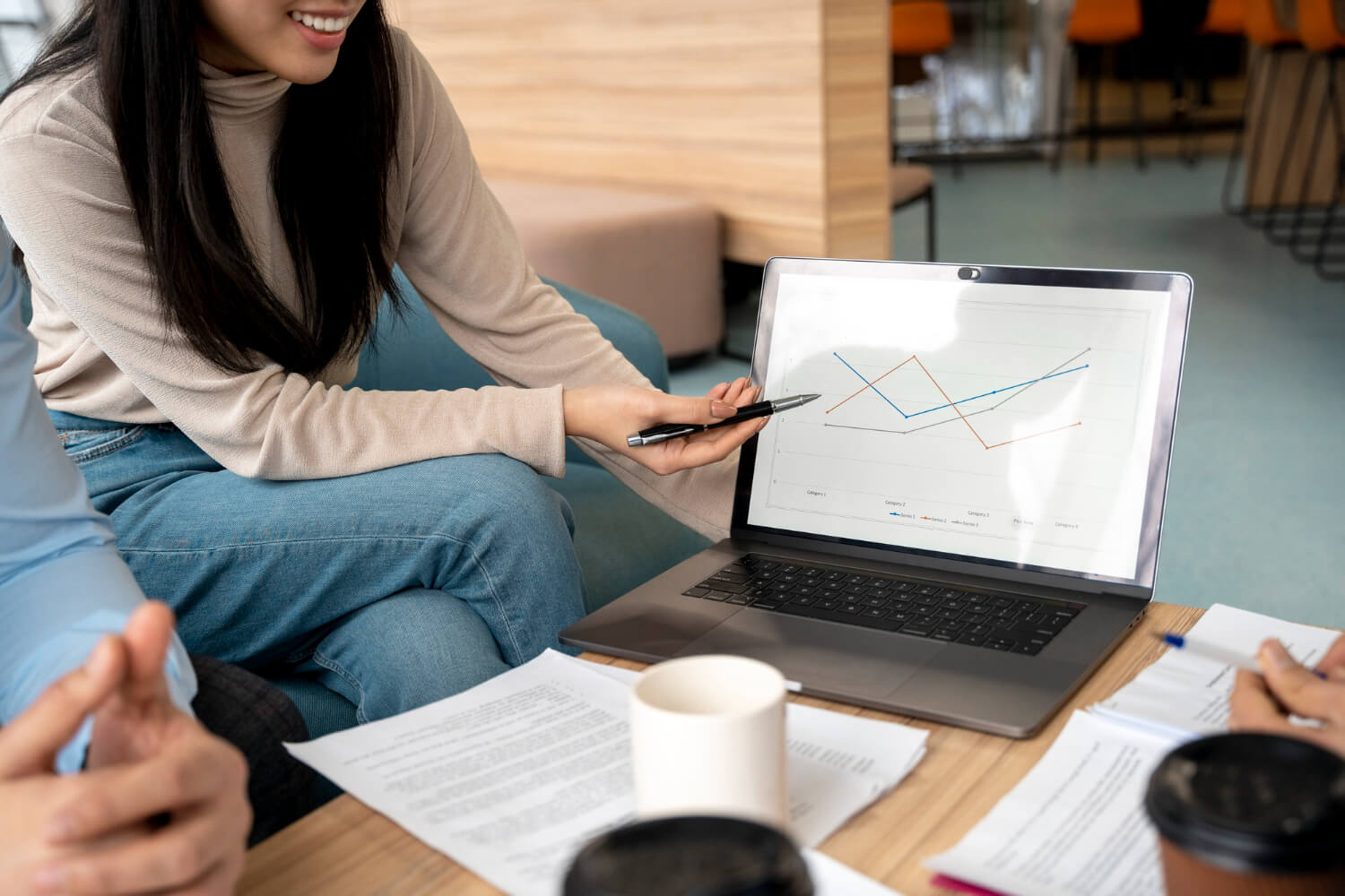 A young lady presenting at a meeting with her laptop