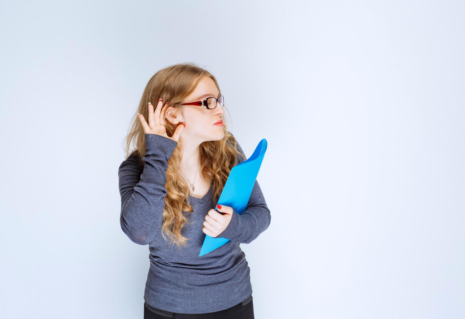 A lady listening attentively while holding a blue folder