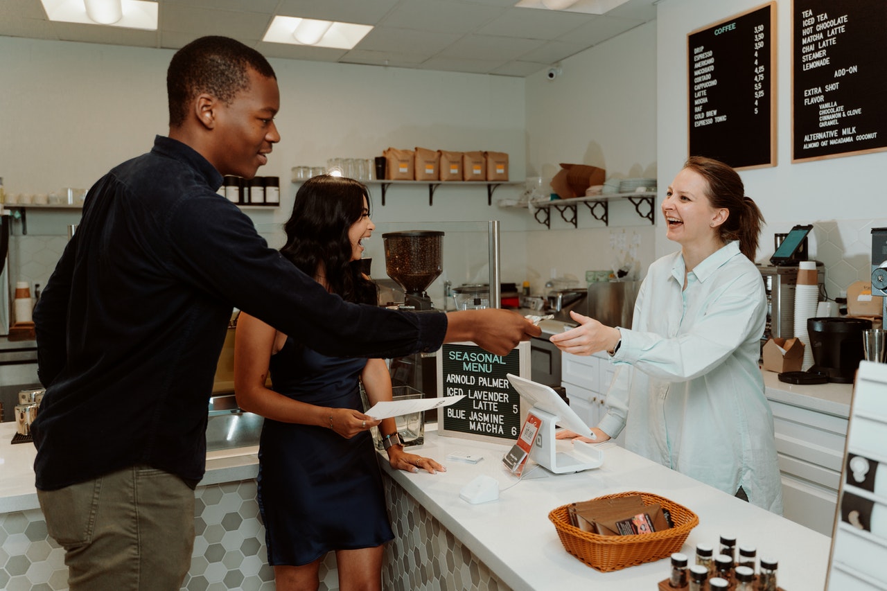 A-man-paying-his-bills-to-the-smilling-cashier-in-a-grocery-store.