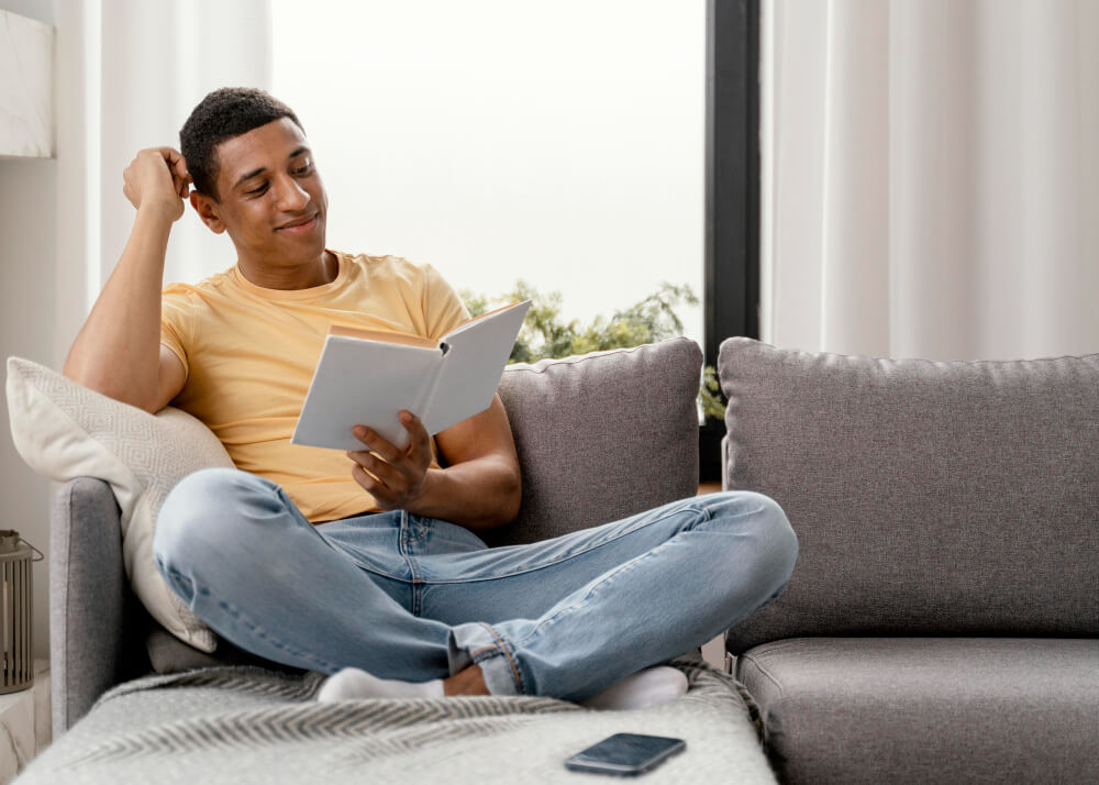 A-man-sitting-on-a-couch-and-reading