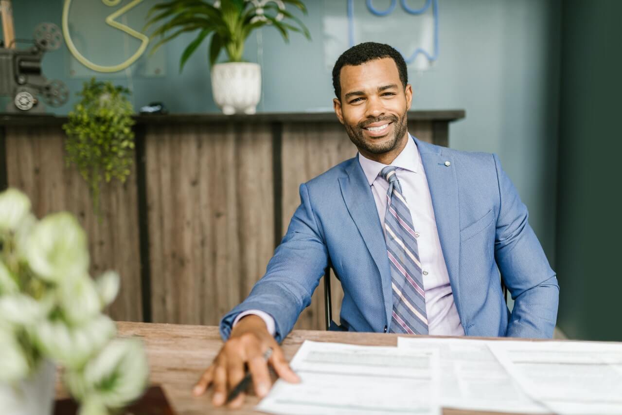 A smiling sole proprietor in his office - Best Bank Account for Sole Proprietor in 2022