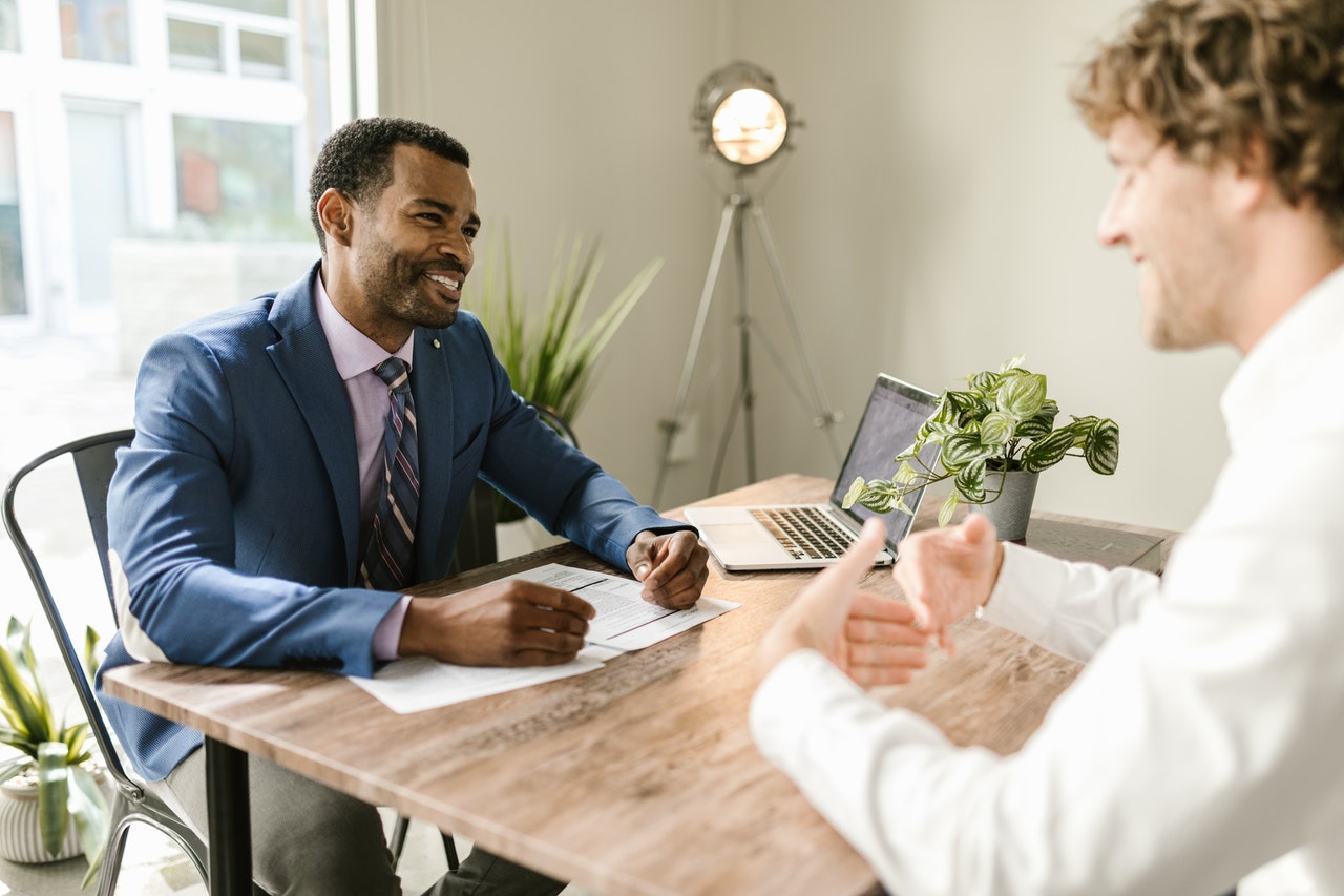 Business men smiling while discussing in a meeting