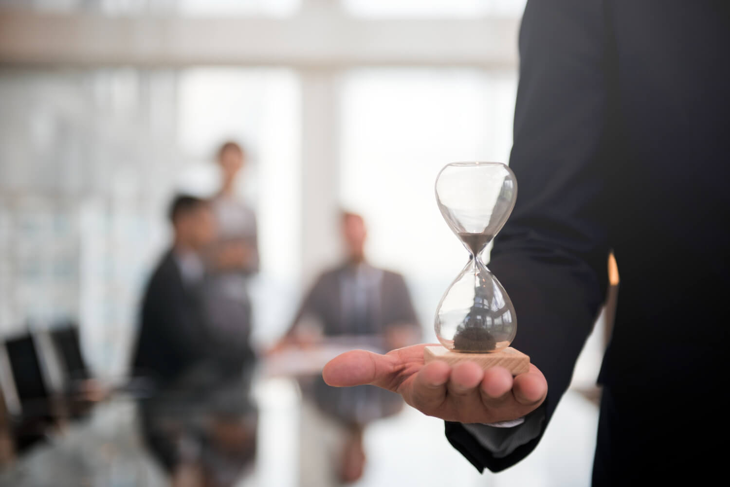 Business man holding an hour glass