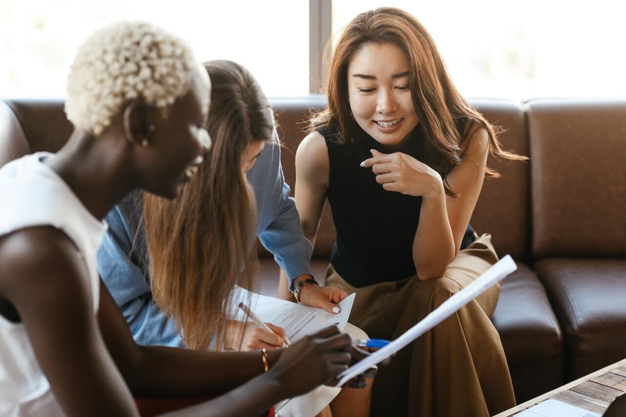 Cheerful colleagues having a meeting while going through a document