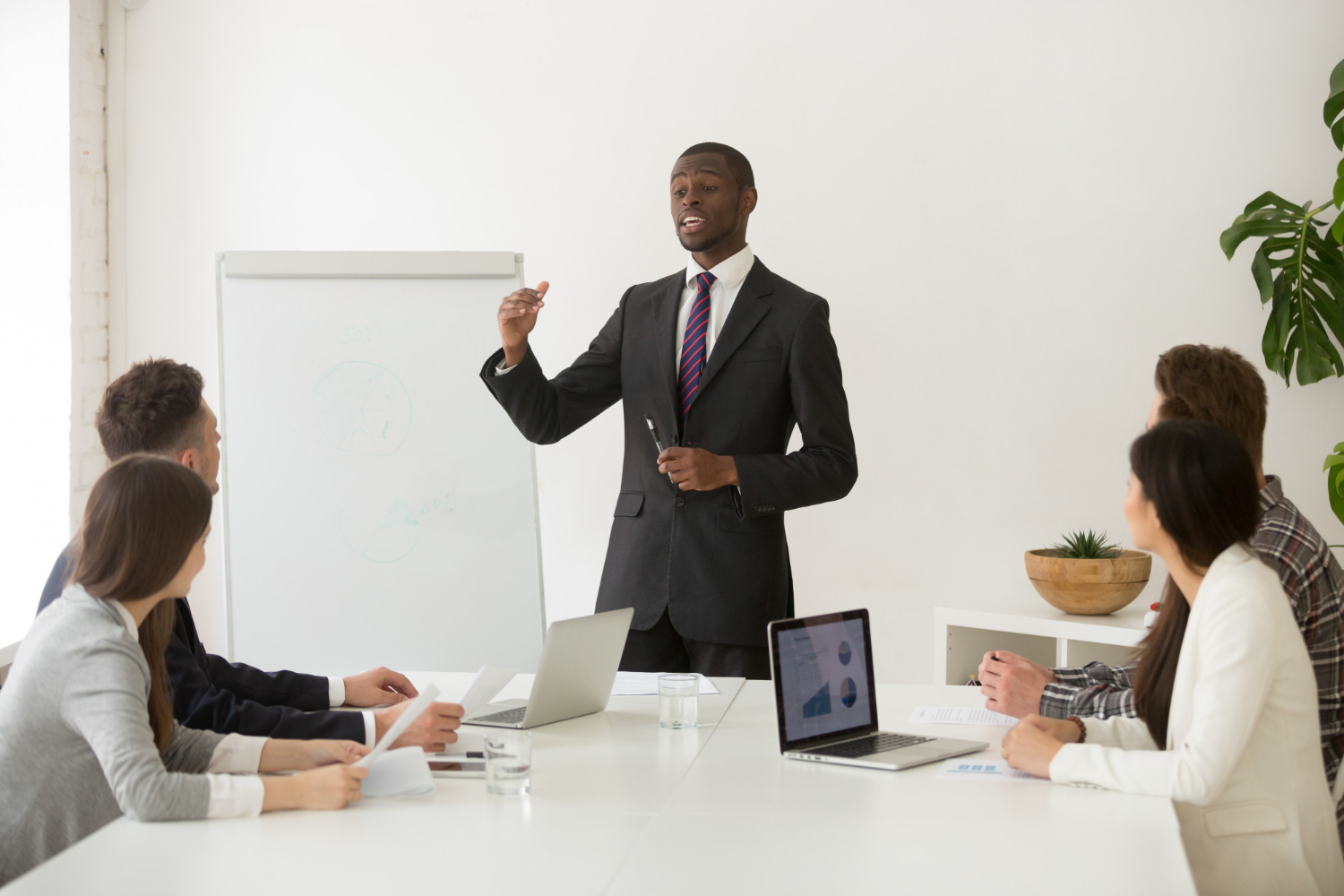 A young black man presenting to his team