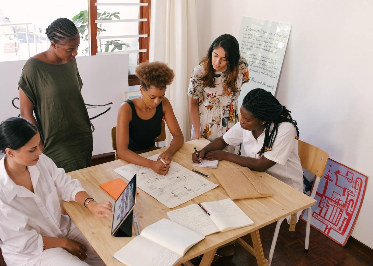 Group-of-female-workers-laying-down-a-mapped-plans