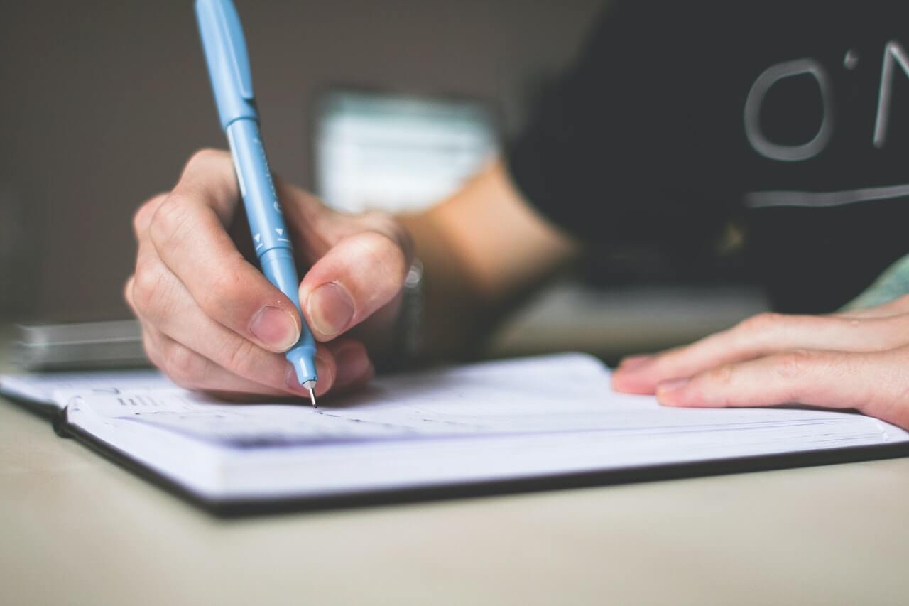 A writer writing on a notebook