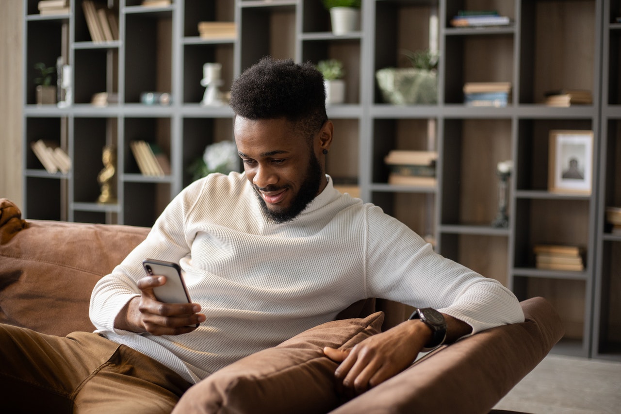 Young man on smartphone while smiling