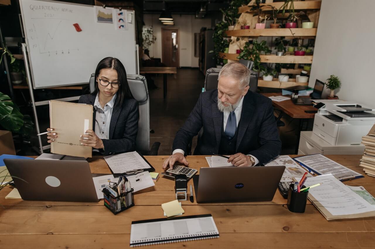 Two-colleagues-working-on-their-desk-in-their-office.