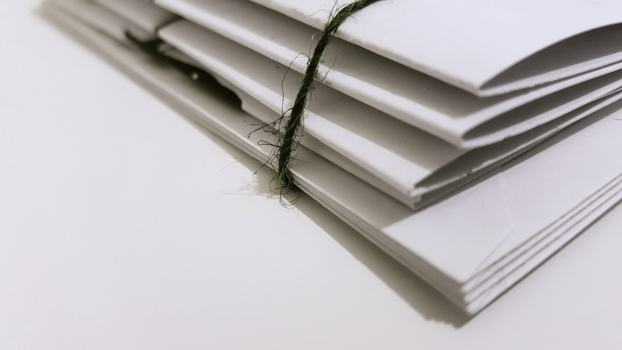 White Paper Folders Of Documents With Black Tie