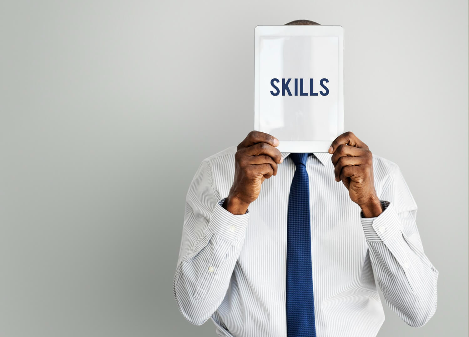 Young man holding a sign saying skills