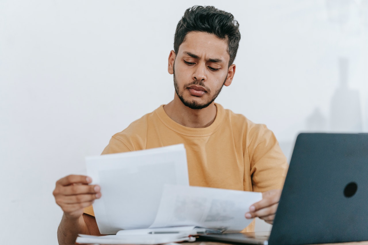 Young man going through a document at workplace