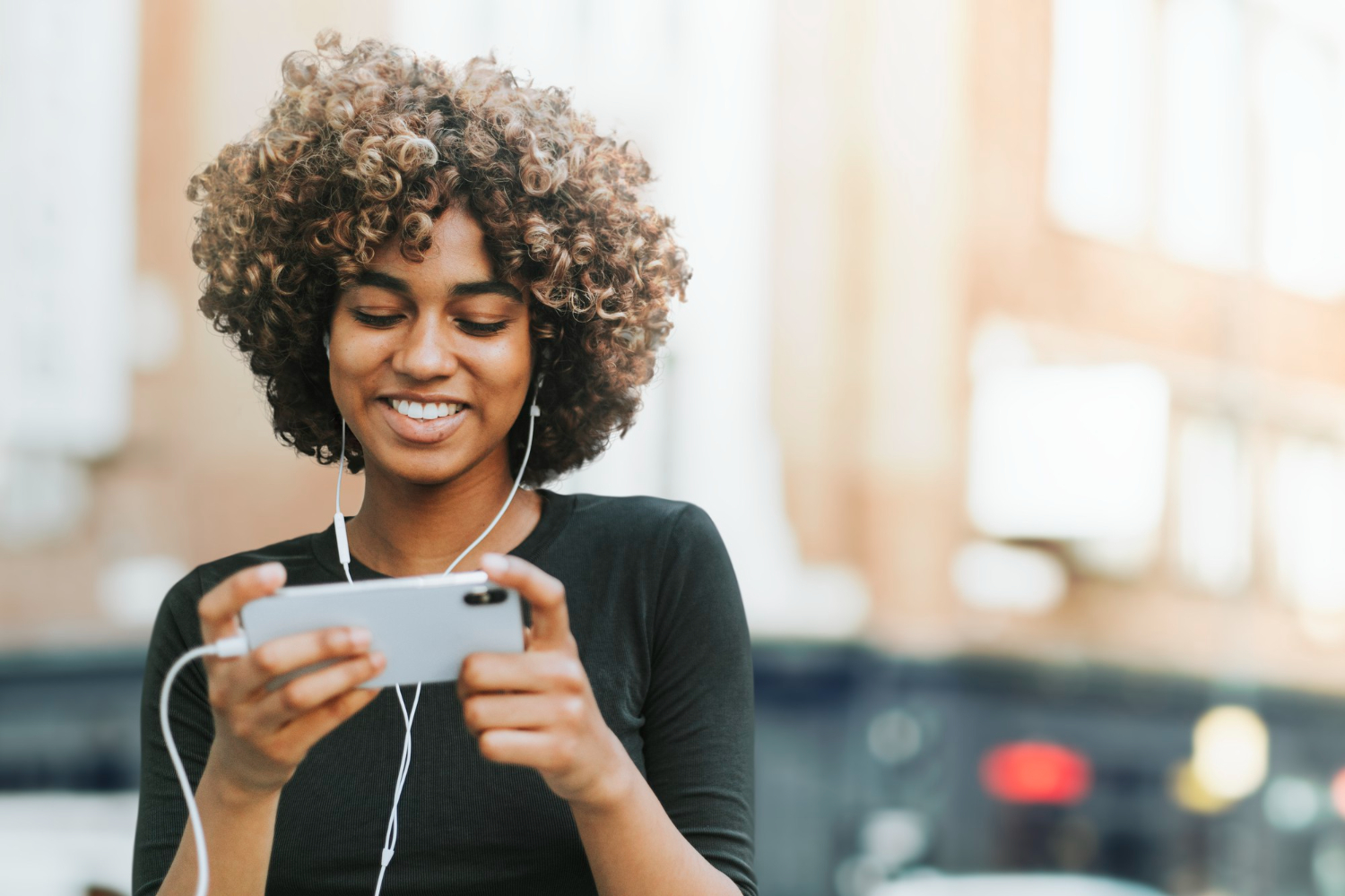 Young woman smiling down at her phone