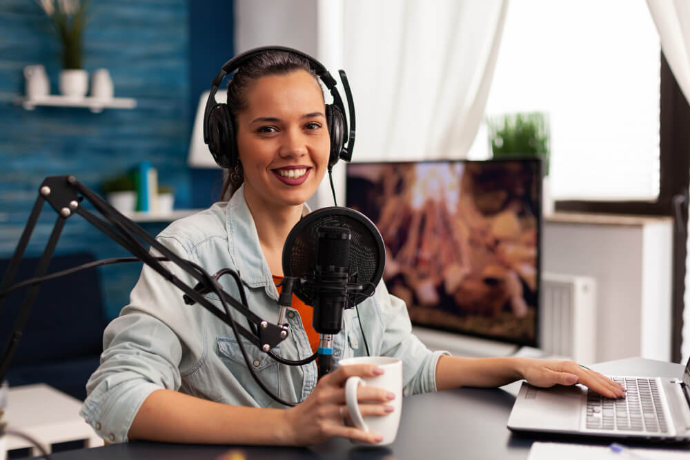 A lady sitting in front of a camera recording a talk show