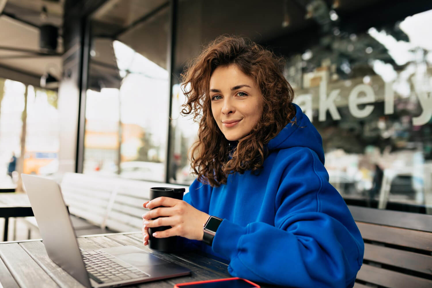 A-female-worker-outside-drinking-coffee-and-working