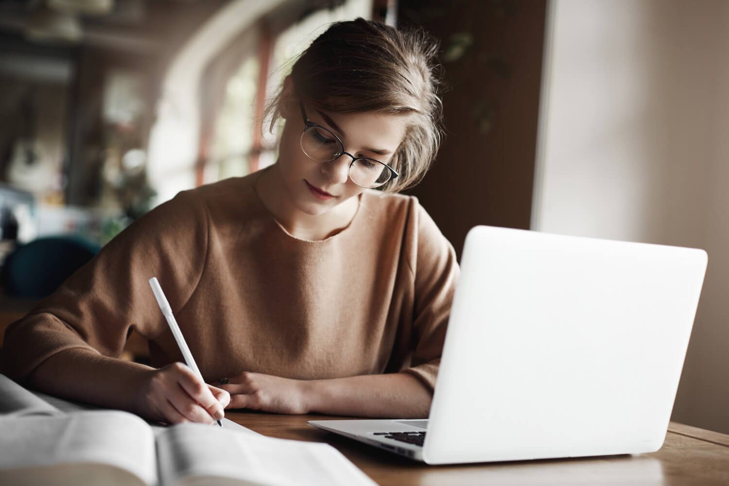 Young focus lady working while making notes