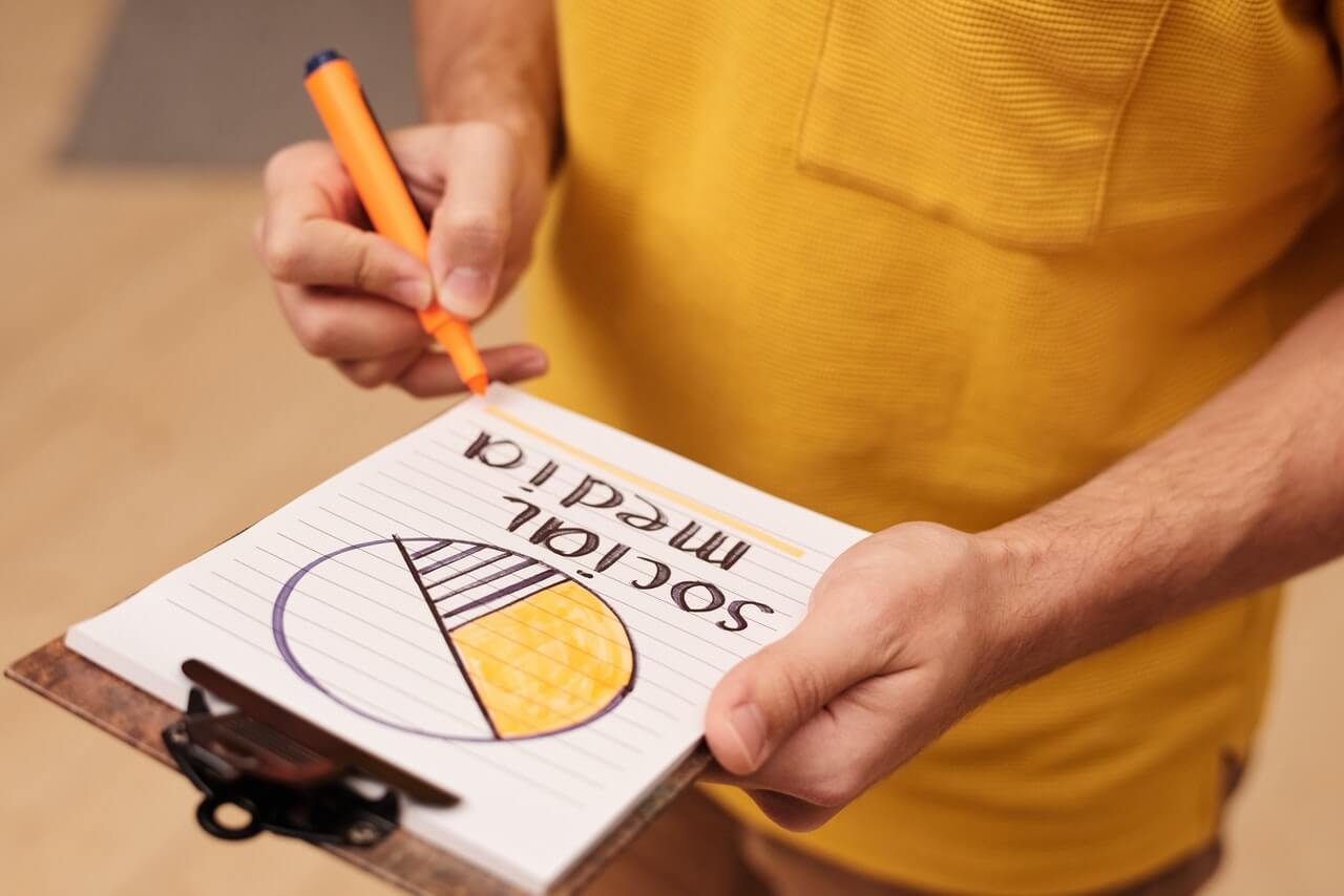 Man holding a note while noting down social media